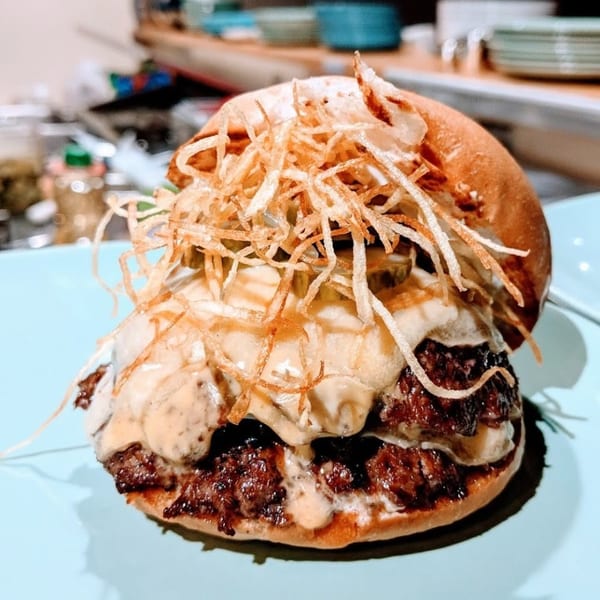 A double smash burger with melted cheese, pickles, special sauce, and crispy fried onions.